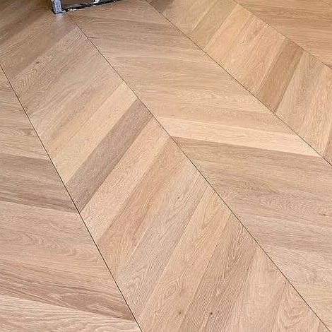 Close view of chevron flooring, the boards cut on an angle into a continuous zigzag